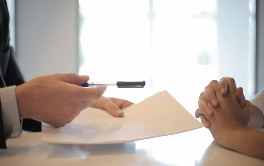 hands holding a pen and paper